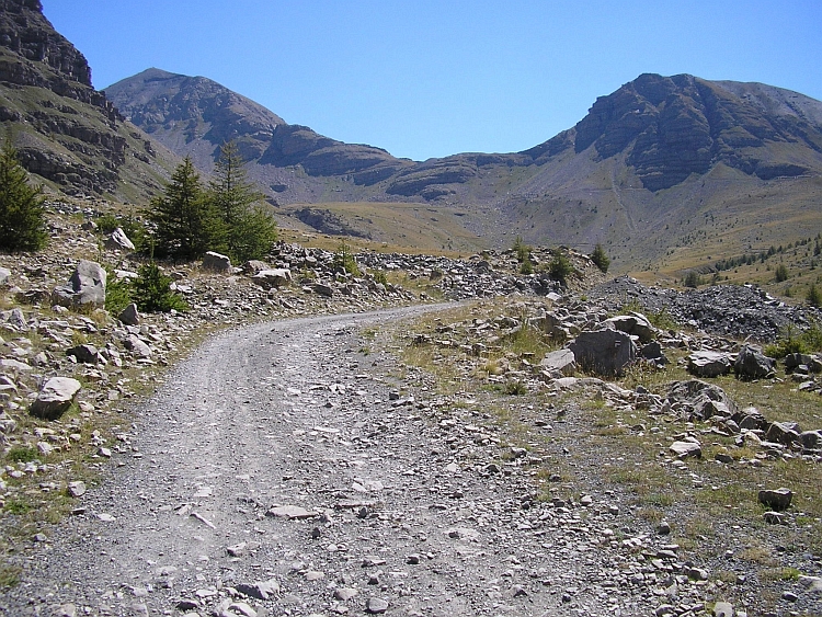 Road to the Col de la Moutière. The saddle between the two mountains is the Col de la Moutière. The left mountain is the Cime de la Bonette.
