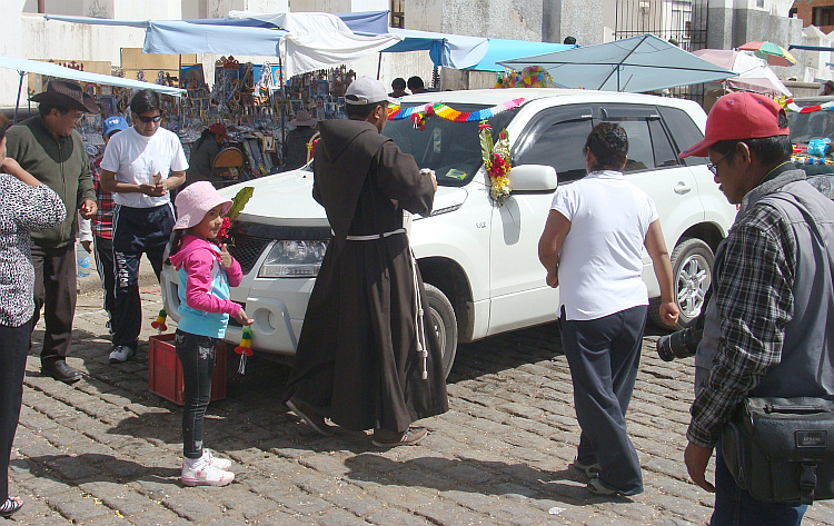 The priest is blessing the cars