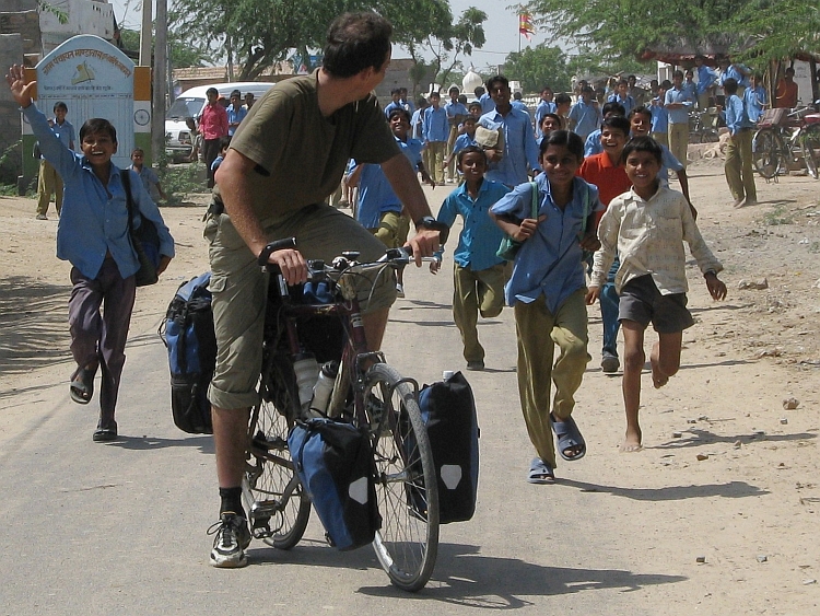 Overal vrienden op de weg - De Lonely Cyclist wordt uitgezwaaid door schoolkinderen in een dorp in Rajasthan. Foto van Willem Hoffmans