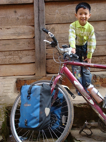 Jongen poseert met mijn fiets in Tansen